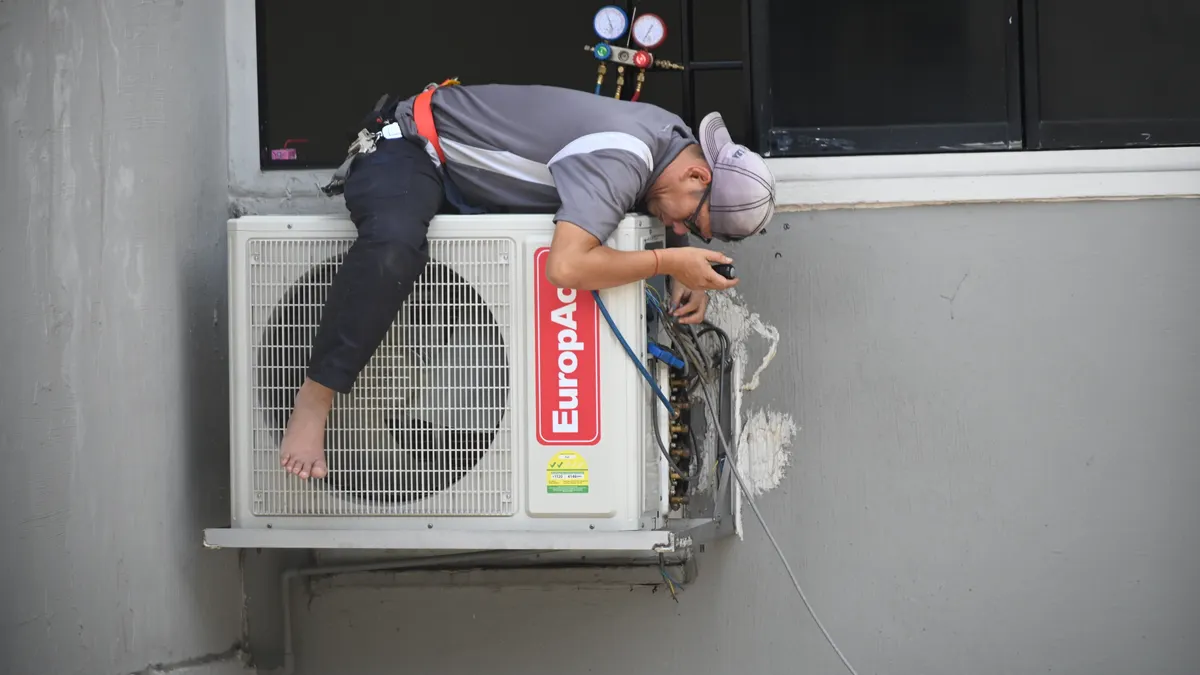 HVAC buying and sizing basics — The Complete Guide Worker servicing an outdoor air conditioner unit